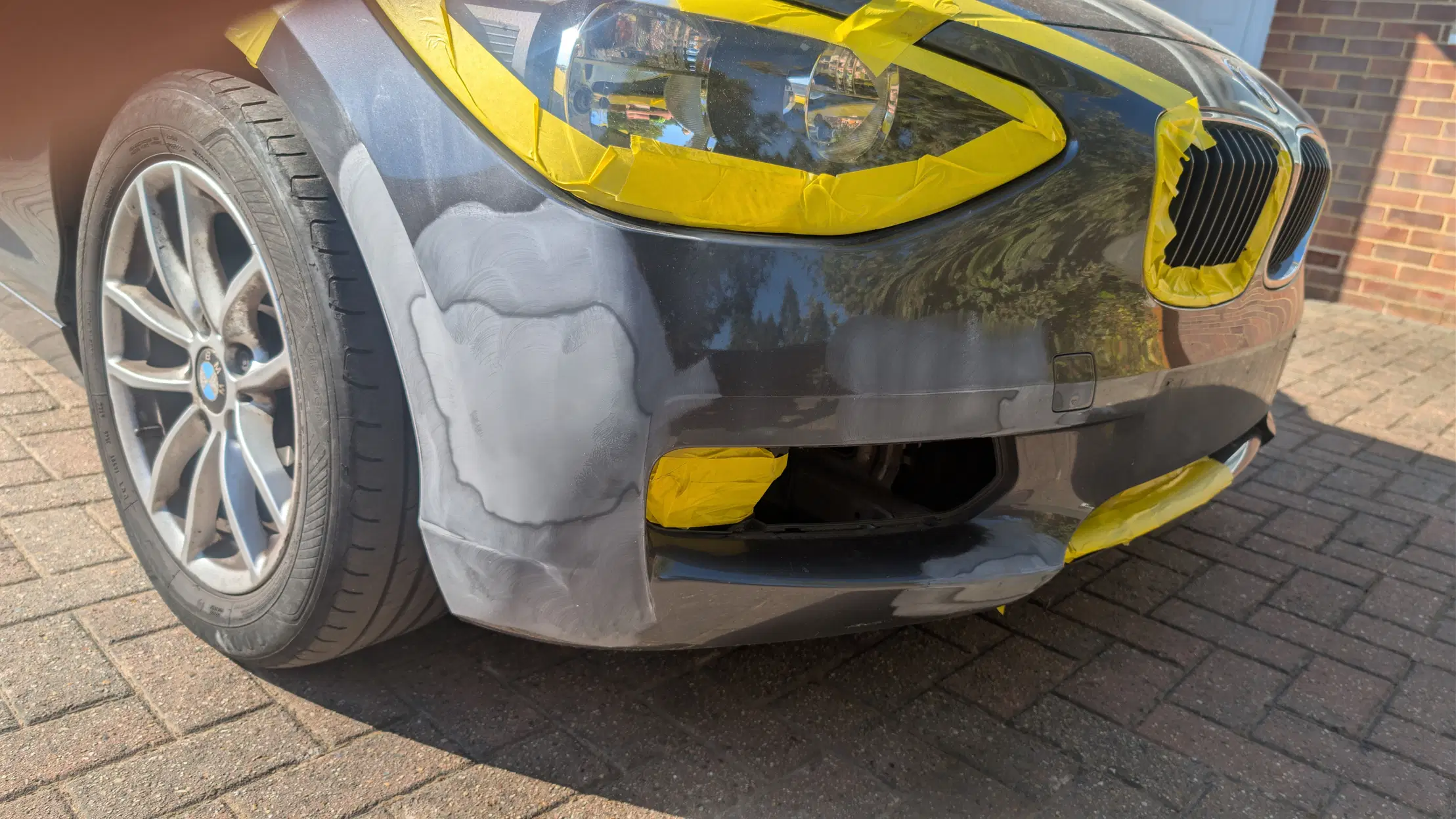 BMW front bumper masked and prepared for repair