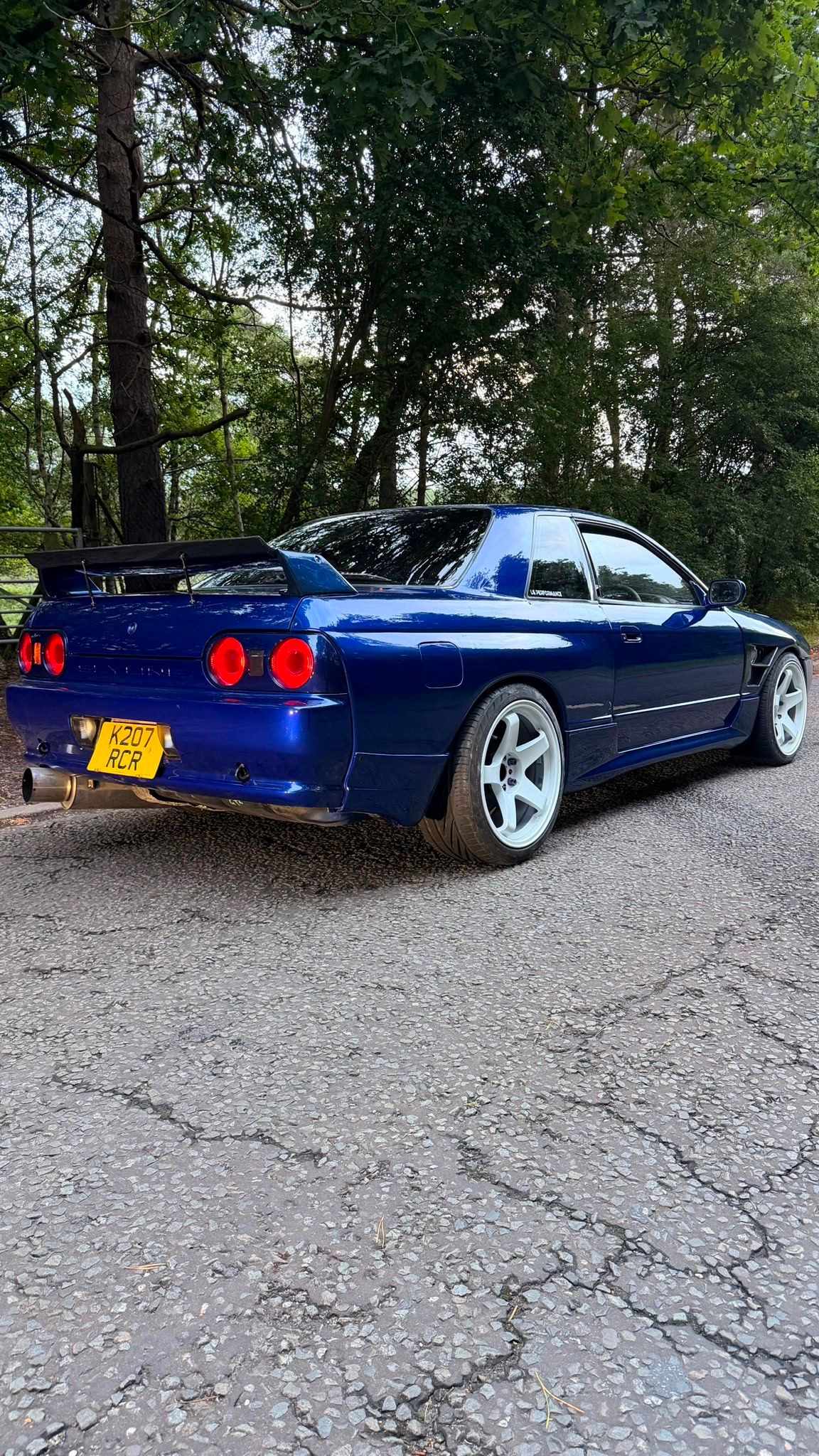Nissan Skyline R32 in blue after its full respray, rear view outdoors